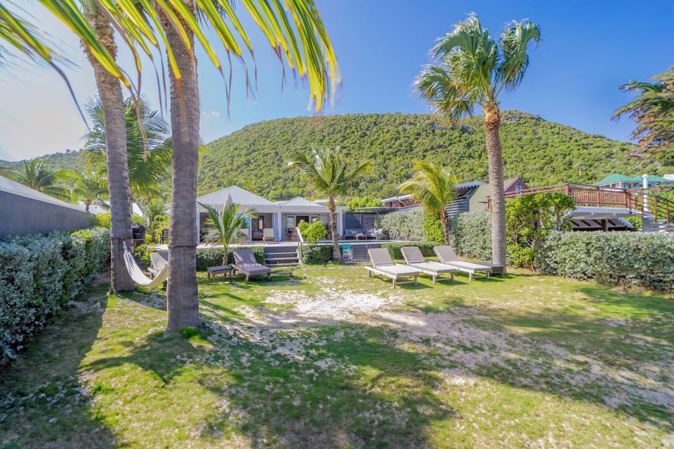 Beachfront property with a direct access on the beach.Nice beachfront garden with tropical flowers, palm trees.  Lounge chairs and hammock under the palm trees. Private parking at the entrance. 