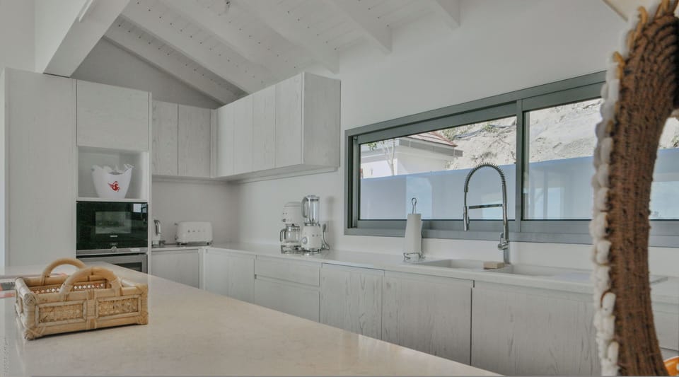 Fully equipped kitchen with a central marble island, bar area and 8 counter stools. 5-burner stove, electric oven, microwave oven, American refrigerator with 2 triple freezers, dishwasher, wine cellar, Smeg filter coffee machine, Nespresso, Smeg kettle, S