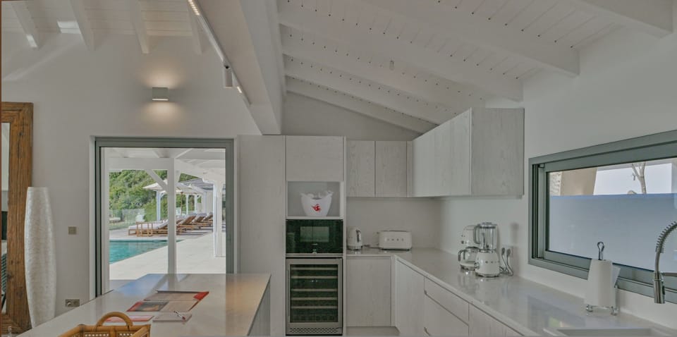 Fully equipped kitchen with a central marble island, bar area and 8 counter stools. 5-burner stove, electric oven, microwave oven, American refrigerator with 2 triple freezers, dishwasher, wine cellar, Smeg filter coffee machine, Nespresso, Smeg kettle, S