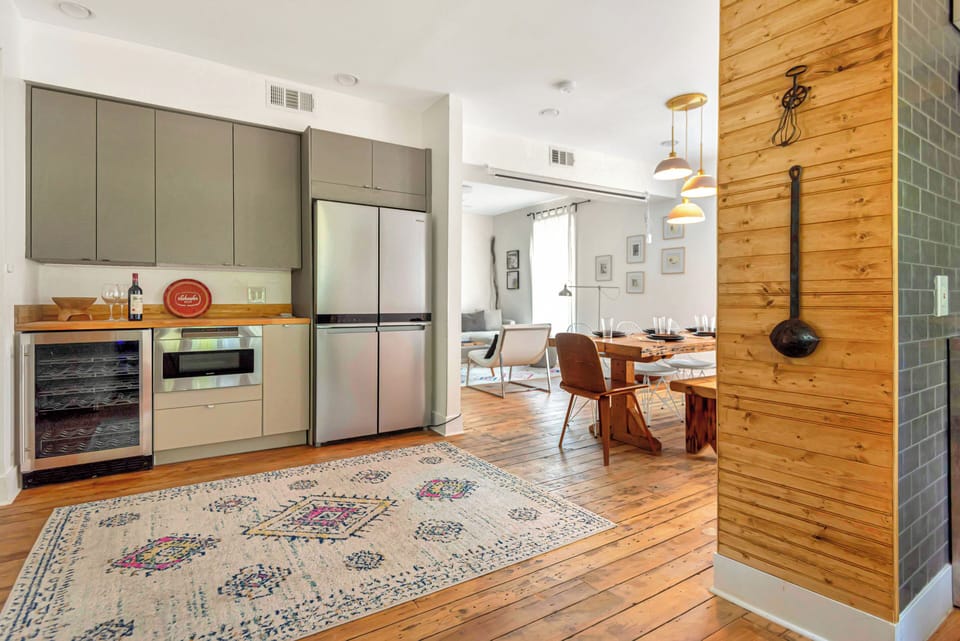 Kitchen and dining area with fridge, wine cooler, microwave, and table for 8.