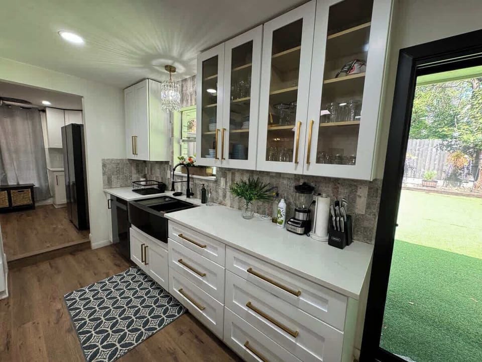 Stainless steel farmers sink, terracota backsplash, cabinets stocked with all the essentials! A chandelier over the sink, Iconic right?!