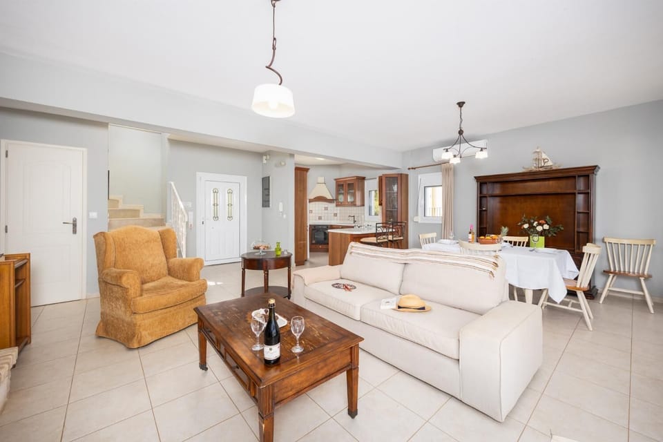 Open-plan living room with sofa, dining area, kitchen, ornamental fireplace, A/C, WiFi internet, and satellite TV