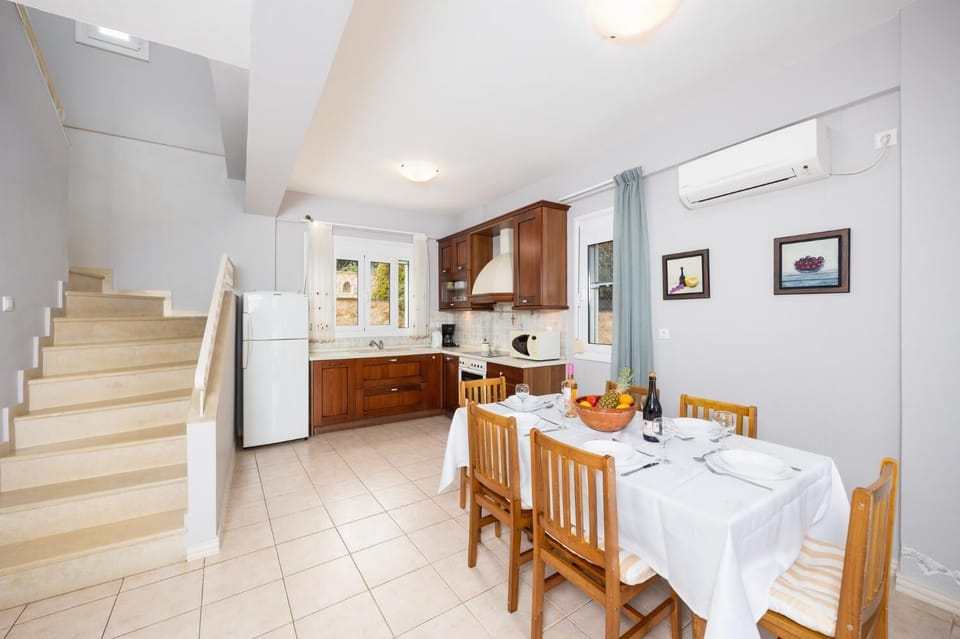 Open-plan living room with sofa, dining area, kitchen, ornamental fireplace, A/C, WiFi internet, and satellite TV