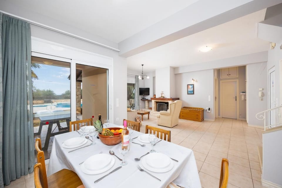 Open-plan living room with sofa, dining area, kitchen, ornamental fireplace, A/C, WiFi internet, and satellite TV