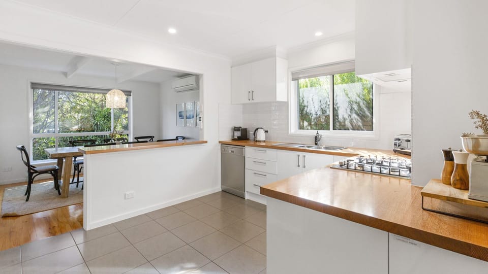 Open plan kitchen with breakfast bar and four stools.