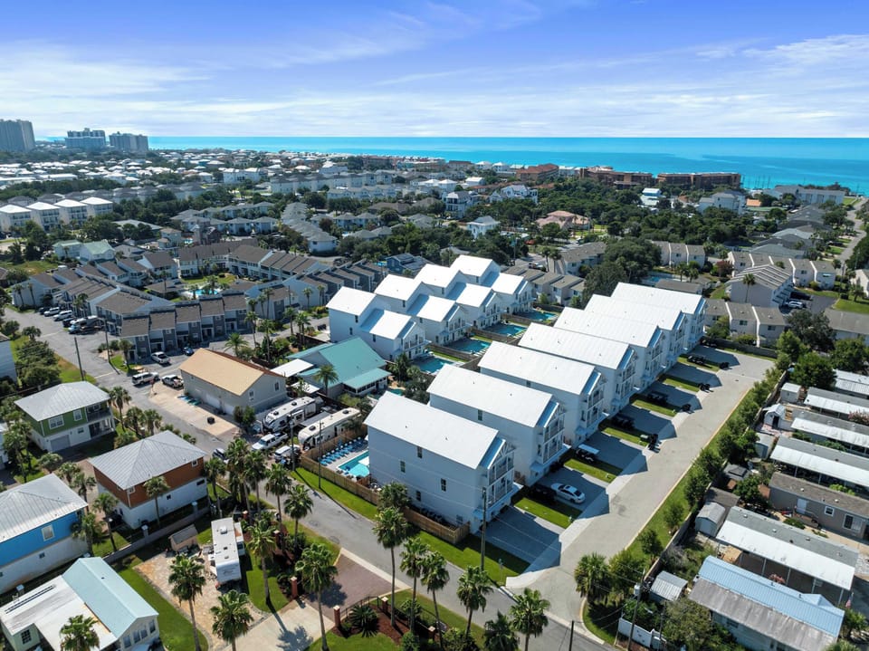 Aerial view of a neat coastal community w/ orderly homes & streets