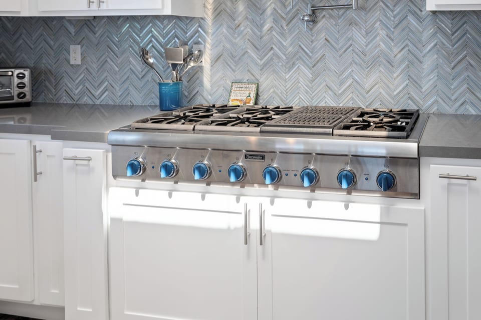 Six burner cooktop with a grill and a pot-filling faucet.