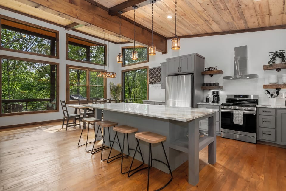 A large island with barstools, and a dining table with seating for eight.
