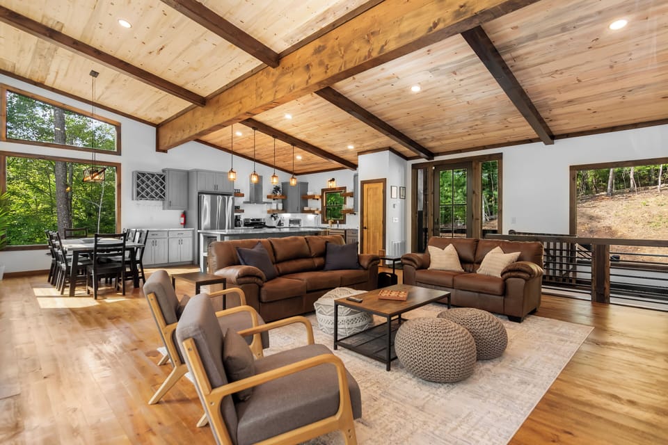 A wide view of the open-concept living room and kitchen shows a rustic charm.