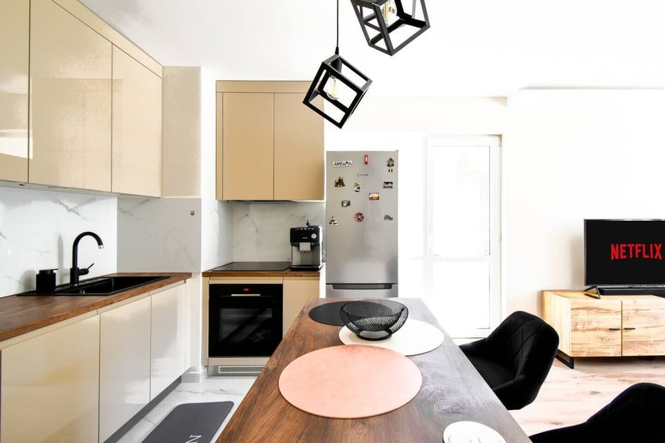 Enjoy a seamless blend of cooking and entertainment in this modern, open-concept kitchen and living area. The sleek design features top-of-the-line appliances and stylish lighting, creating a welcoming space for both culinary adventures and relaxation.