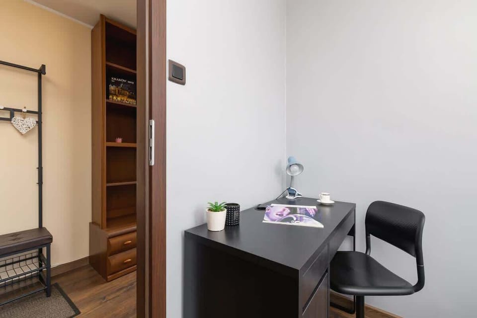 Small home office with a desk, rolling chair, and bright windows.