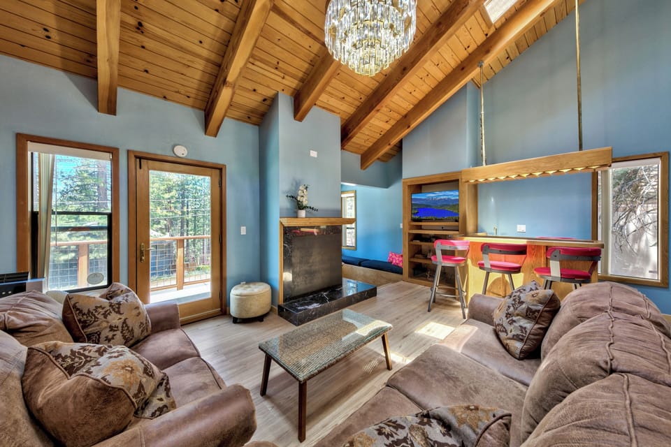 Sink into plush sofas beneath soaring wood beams. Your mountain retreat awaits with stunning vaulted ceilings and warm natural light.