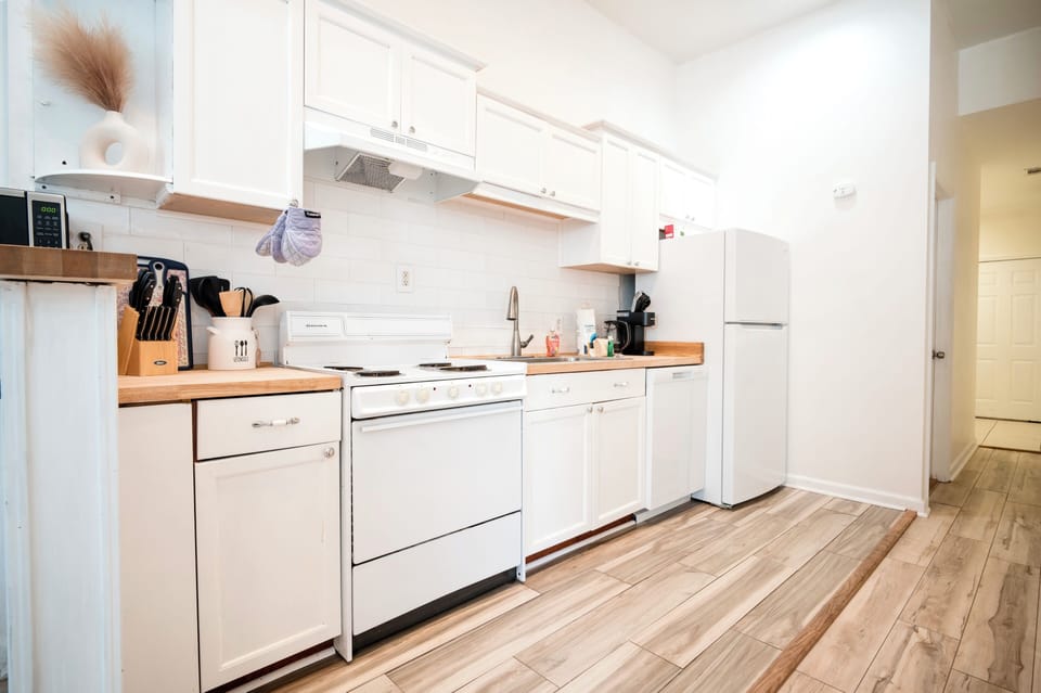 Full kitchen with fridge, dishwasher, oven, microwave, stove and coffee machine.