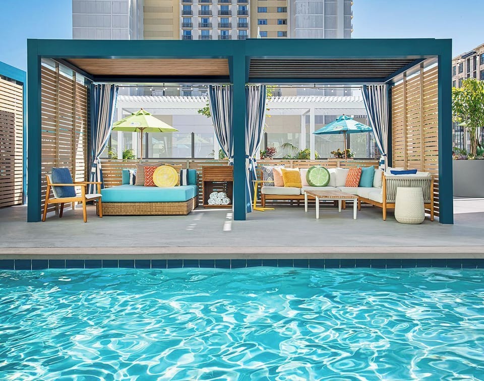 Lounge in private cabanas with breezy shade and plush seating.