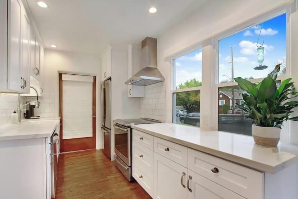 Galley kitchen with induction range, lots of prep space, leads to utility room