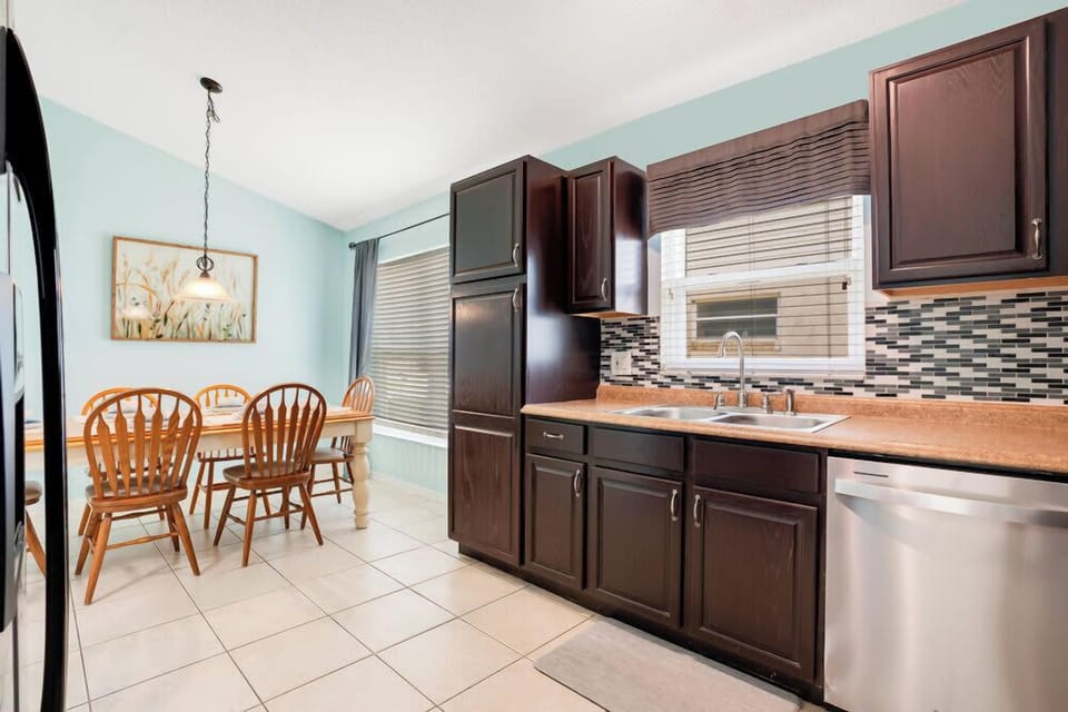 Bright kitchen with dark wood cabinets and a cozy dining area.
