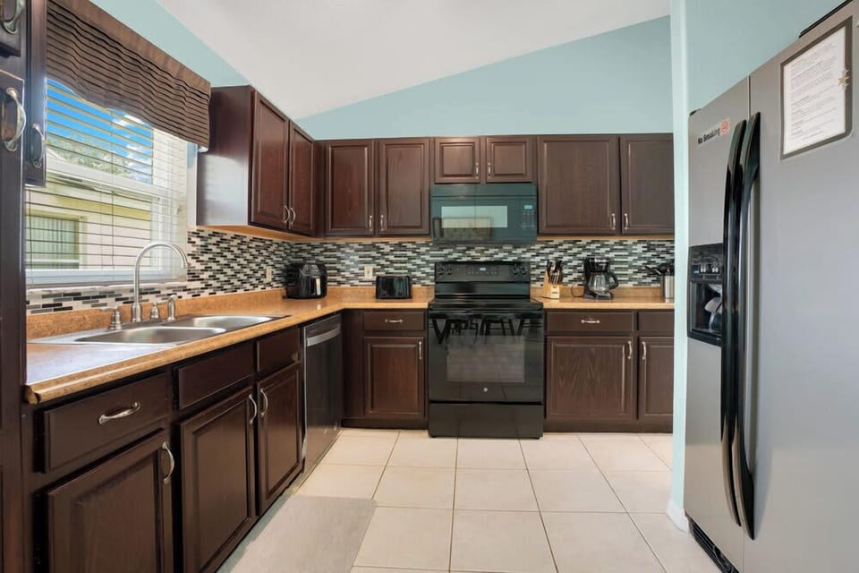 Modern kitchen with dark wood cabinets and stainless steel appliances