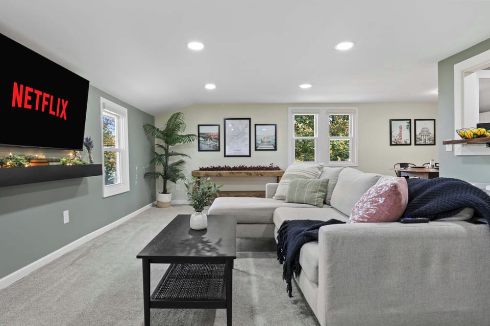 Open concept living with the living room, dining and kitchen area. The living room has a comfy couch, 58" smart TV, and corner swivel chair that's perfect for morning coffee and sight seeing the neighborhood. 