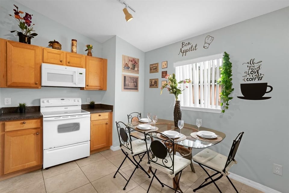 Cozy Kitchen With White Appliances And A Stylish Dining Space