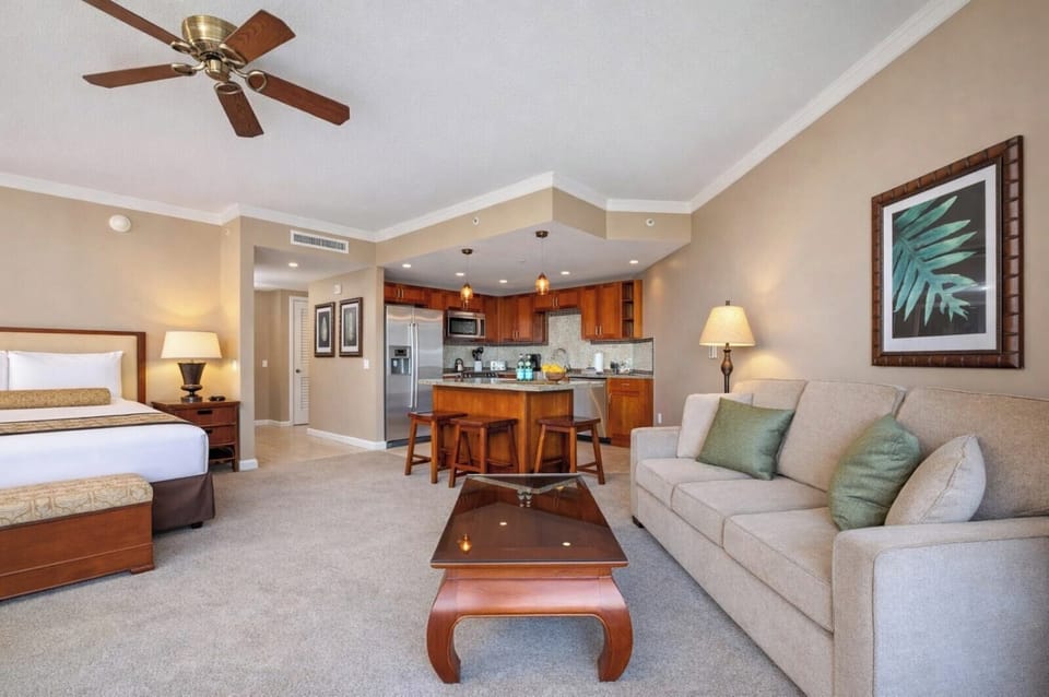 Your open studio welcomes you with a plush bed, sofa seating, and a full kitchen just steps away, creating an easy space for both rest and island living.