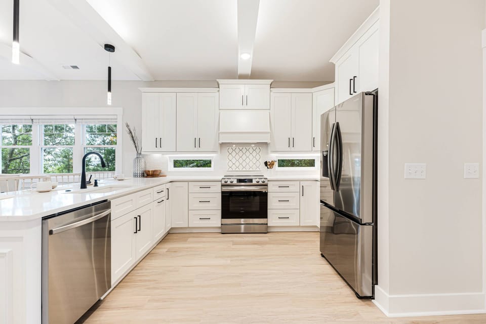 Kitchen with white cabinetry, stainless steel appliances, and ample natural light.