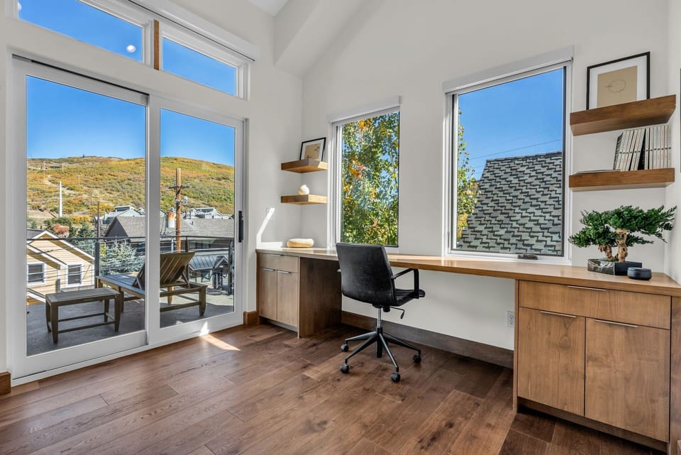 Luxury office setup inside Woodside Main Street Haven with chair, wide wooden desk.