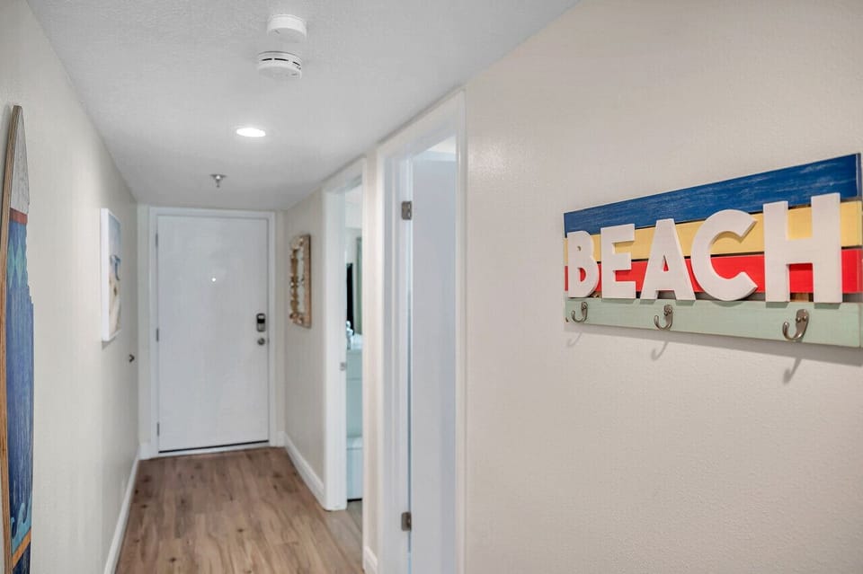 Bright hallway w/ coastal artwork sets a cheerful tone as you enter.