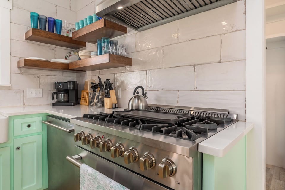 Your fully equipped kitchen awaits with professional-grade appliances and charming mint-green cabinetry, perfect for creating memorable meals together.