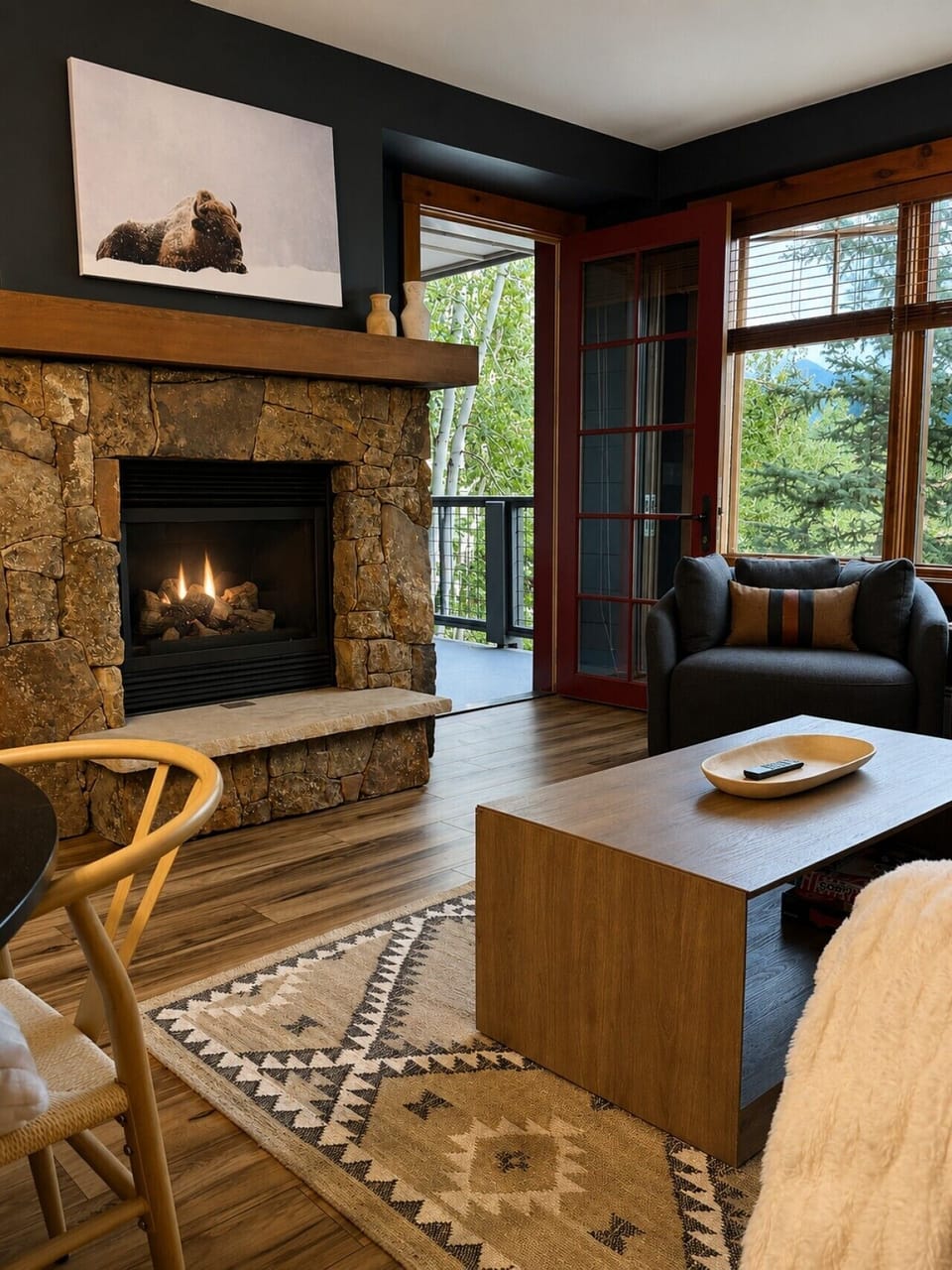 Spacious living area with swivel chairs, fireplace, comfortable sofa and access to a private balcony