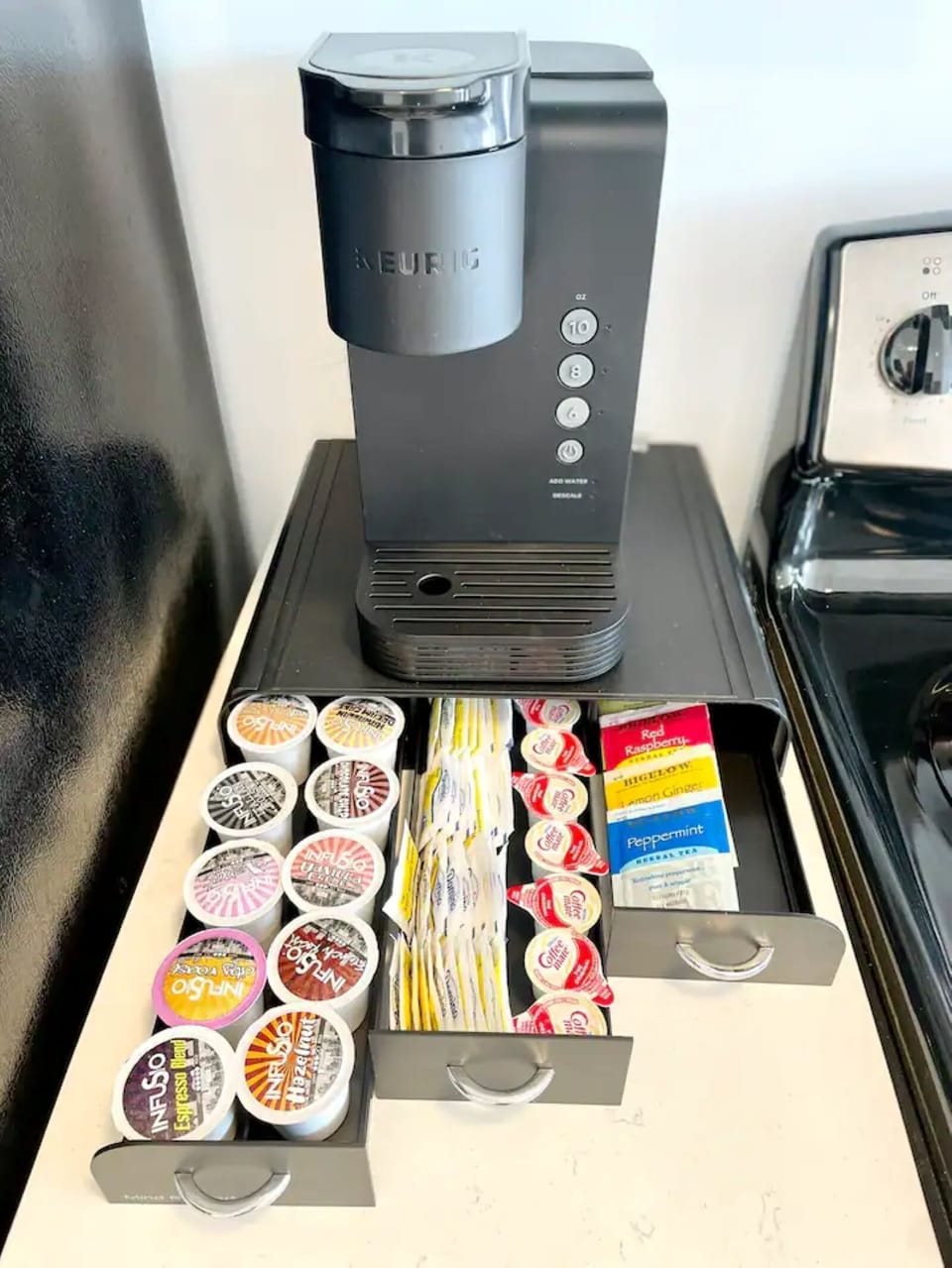 Keurig machine with coffee pods, sugar, creamers and variety of teas.
