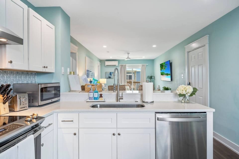 Cook and stay connected in this open-concept kitchen, offering a clear view of the living area and TV,  perfect for entertaining or keeping up with your favorite shows.