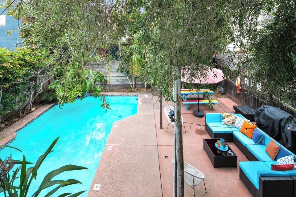 Backyard as seen from the second floor balcony, Relax in the spacious lounge area with colorful seating and shaded umbrellas.