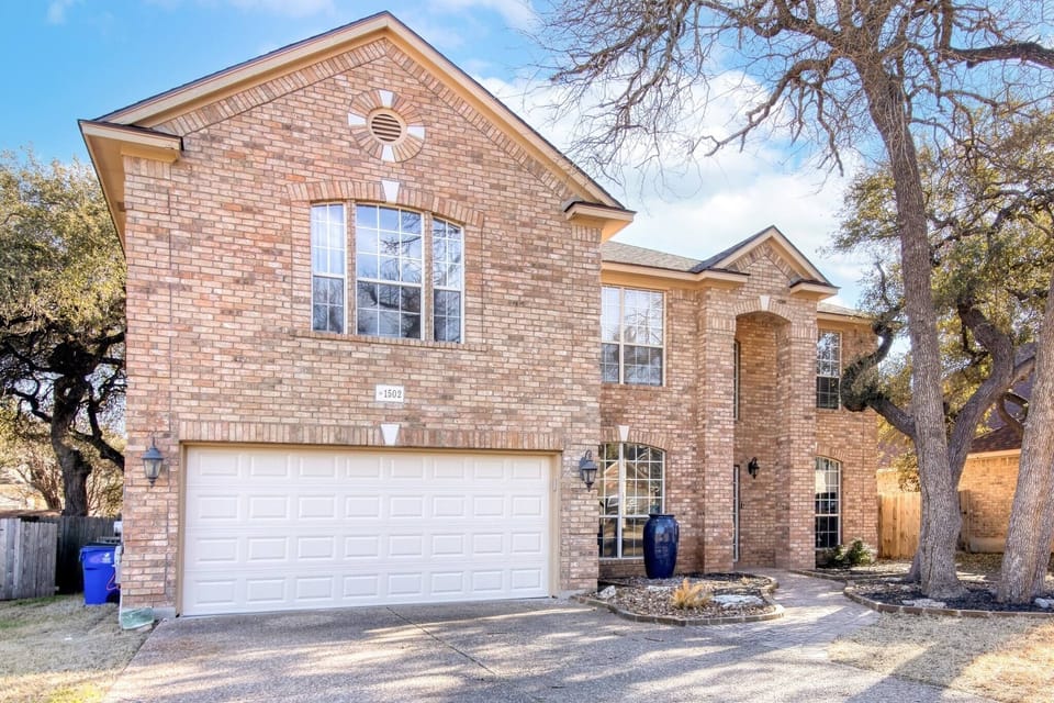 The exterior showcases a simple and modern brick design, offering a clean, timeless aesthetic. A garage at the front adds convenience and functionality to this charming house.