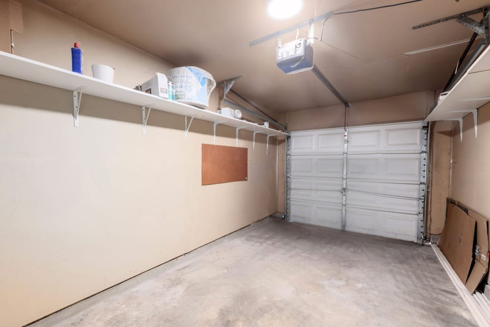 Spacious single-car garage with built-in shelving for extra storage, perfect for keeping your belongings organized during your stay. Additional reserved parking for one car in the driveway.