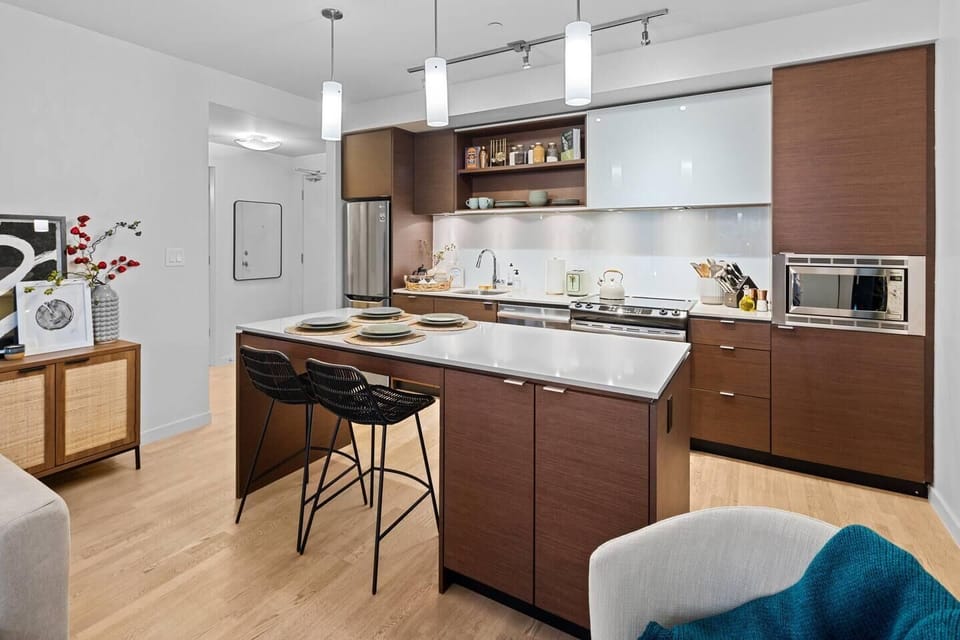 Channel your inner chef in a premium, fully equipped kitchen layout boasting dark lower cabinetry and modern white upper cupboards.
