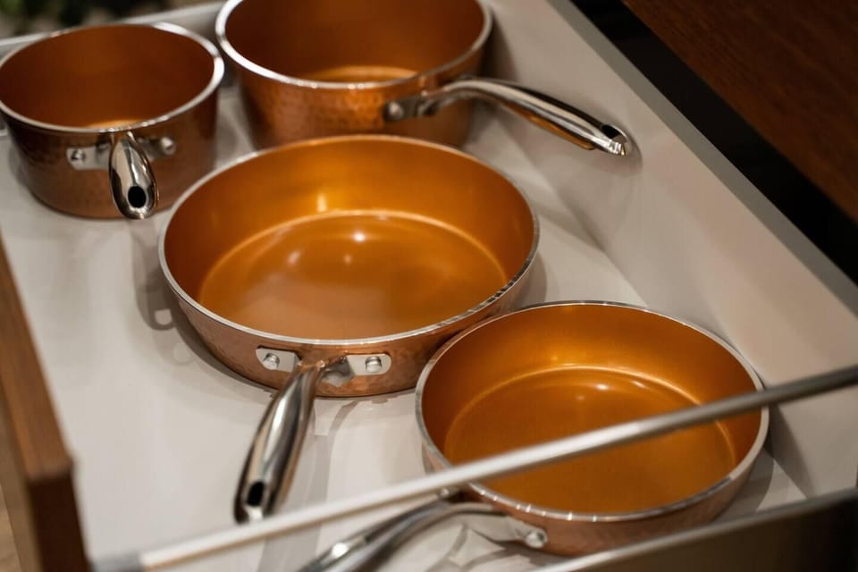 Pull open the drawers to find a complete set of high-quality copper pots and pans ready for home-cooked vacation meals.