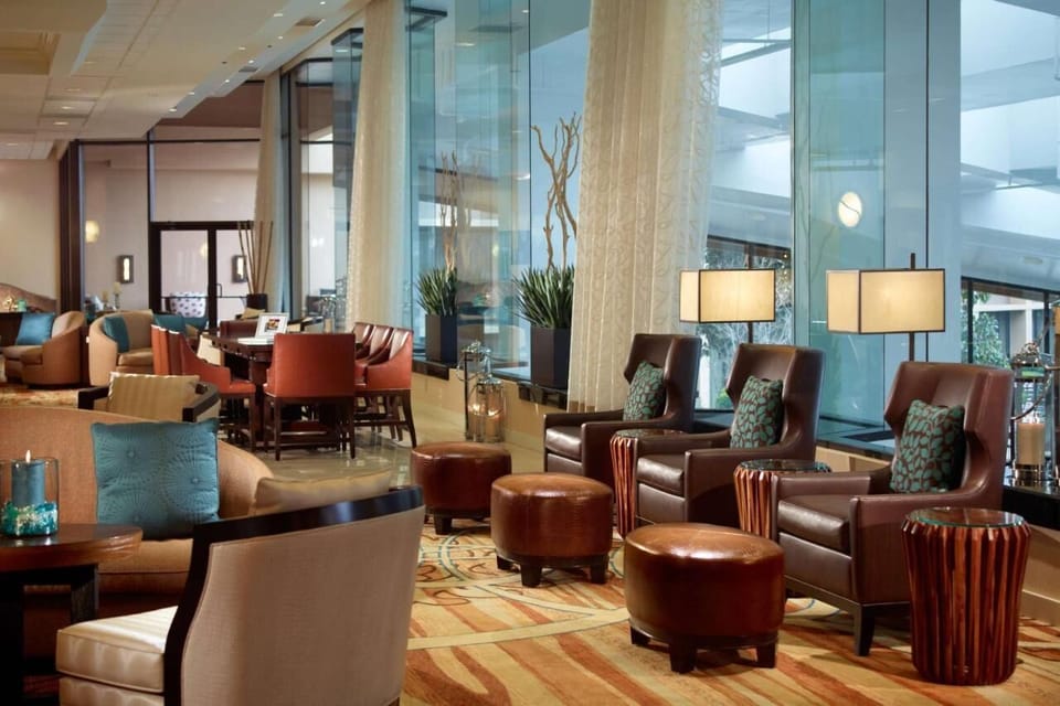Settle into plush lounge seating beside bright, soaring windows.