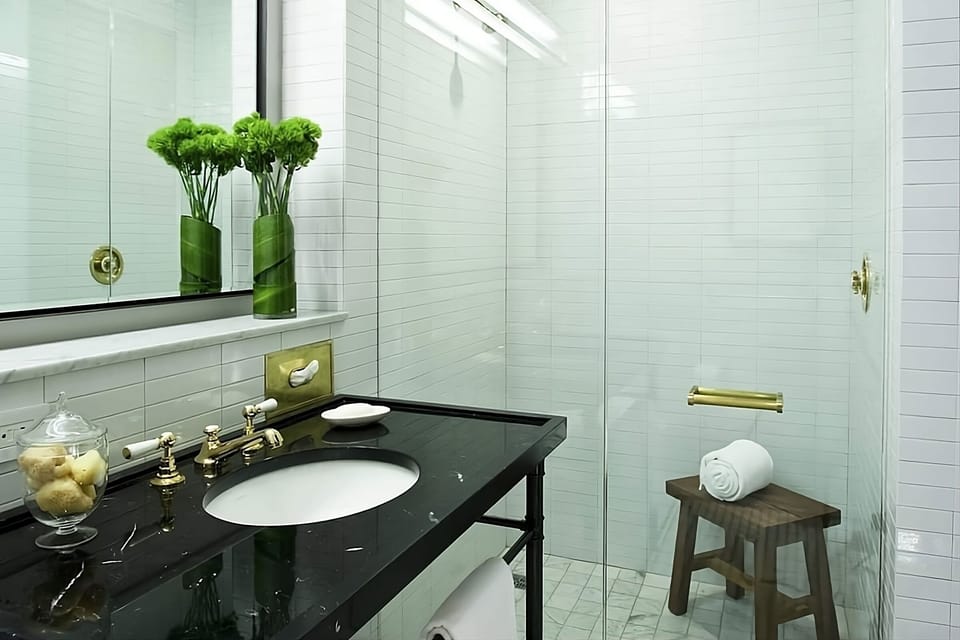 Refresh in a sleek marble vanity bath with glass shower.