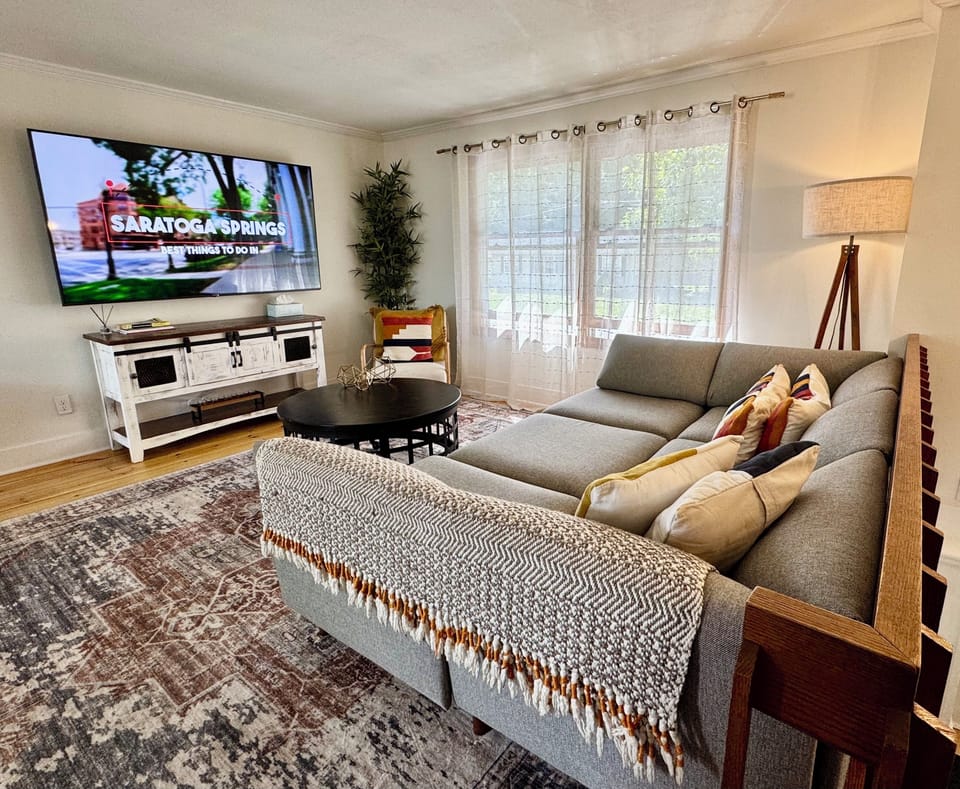 Living area with large sofa and smart TV - connects to kitchen for open concept