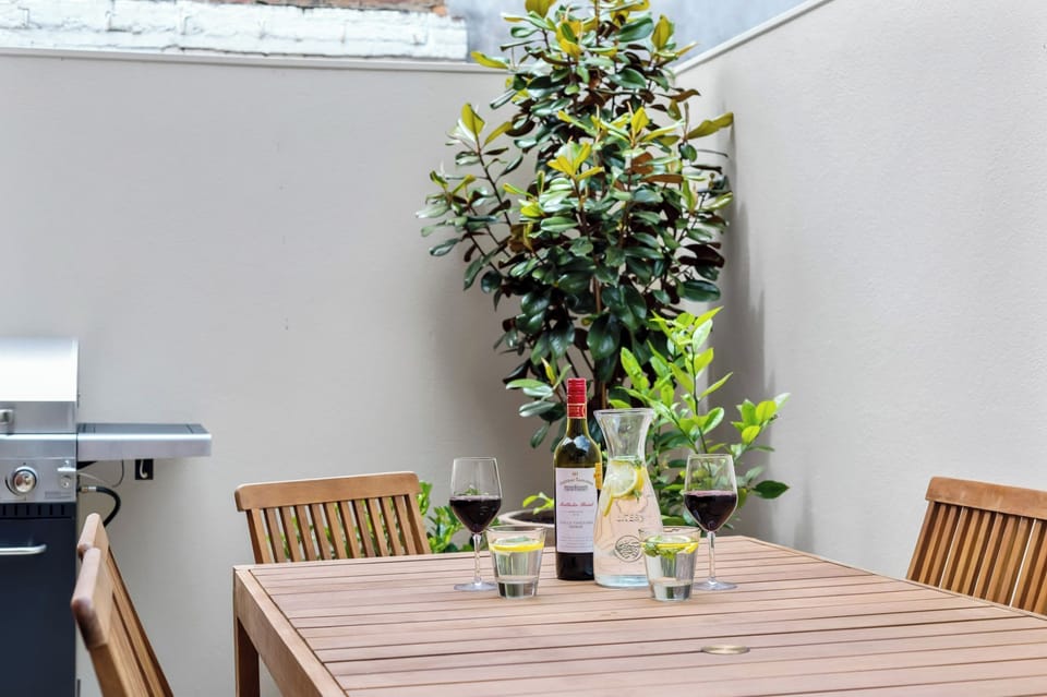 APARTMENT 2 COURTYARD: The sunny courtyard has an outdoor table setting and barbeque that is perfect for relaxing or entertaining.
