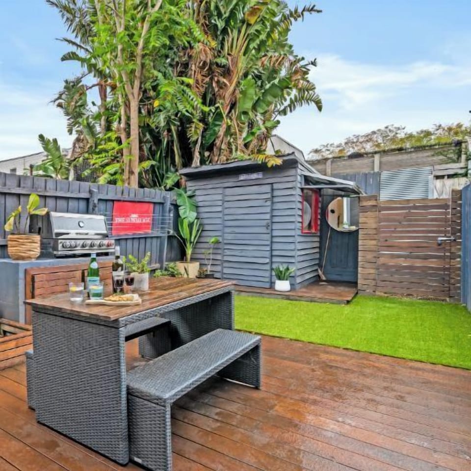 GARDEN DECK: The sunny rear deck has an outdoor table setting and barbeque that is perfect for outdoor living and entertaining. 