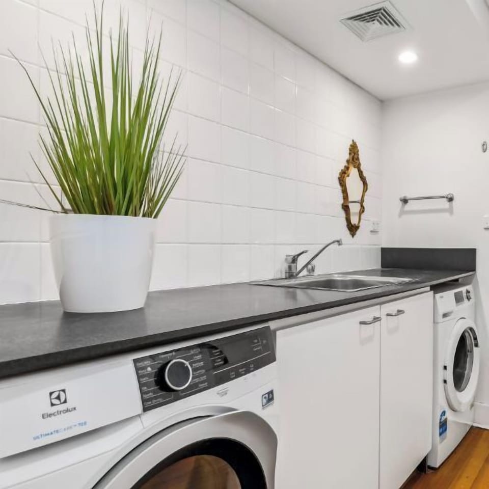 LAUNDRY: The laundry located on the stair landing has a trough, washer and dryer. A convenient toilet for guests is off the laundry. 