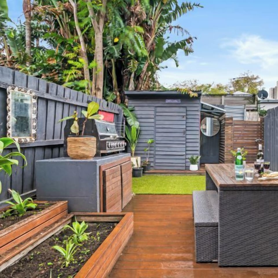 GARDEN DECK: The sunny rear deck has an outdoor table setting and barbeque that is perfect for outdoor living and entertaining. 