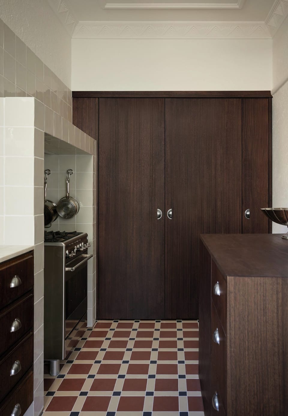 INTEGRATED PANTRY: Behind the bespoke joinery is a well stocked pantry and integrated fridge. The gas cook top and oven respects to apartments bygone period heritage. 