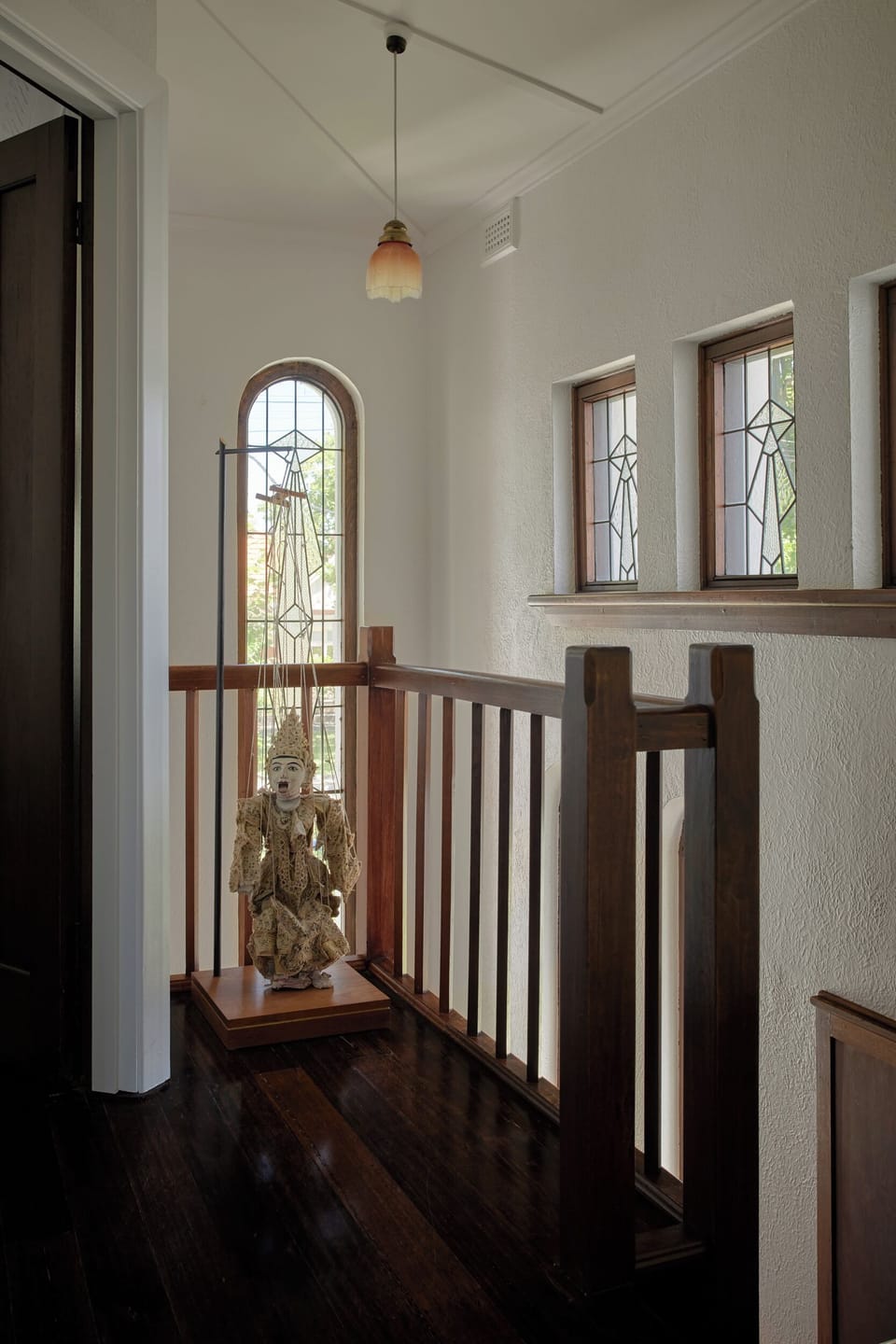 FIRST FLOOR LANDING: The first floor landing features stunning original Art Deco lead-light and a collected antique Burmese puppet. 