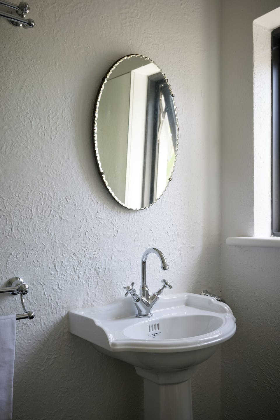 BATHROOM: Homage was paid to the Art Deco era with the heritage pedestal basin, original pie crust mirror that features off the stucco wall. 