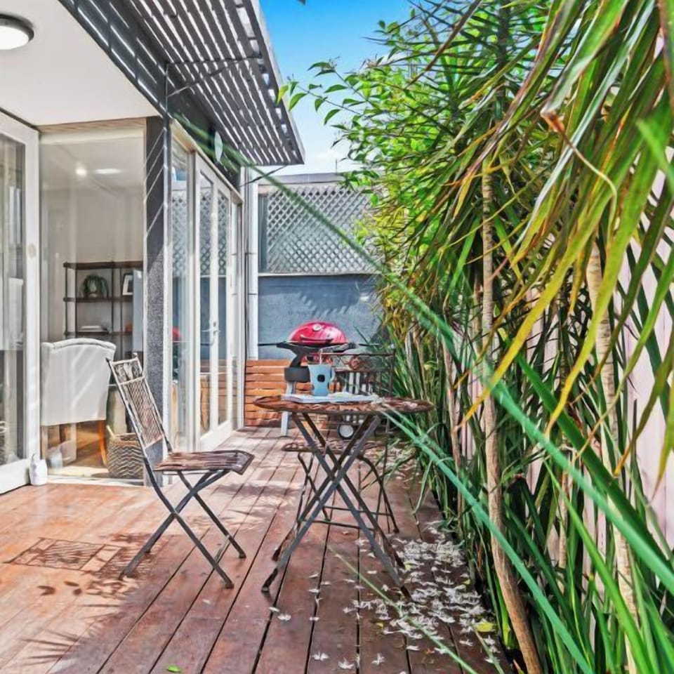 DECK: Off the Living Room is a sunny deck with outdoor setting and barbecue.