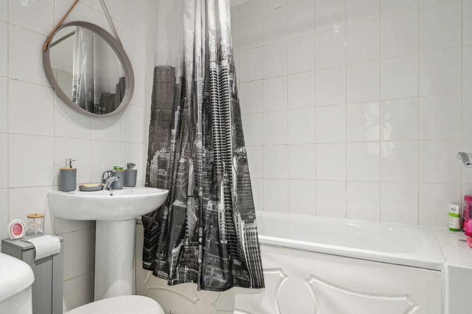 Clean bathroom with bathtub, toilet,  toiletries and fresh towels provided