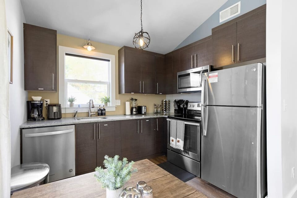 Modern kitchen with stainless steel appliances, dark cabinetry, and plenty of counter space 🍴✨🌿