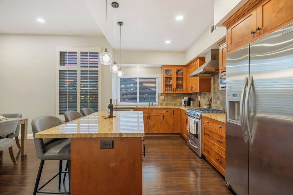 A spacious gourmet kitchen with stainless steel appliances and kitchen island with bar seating.